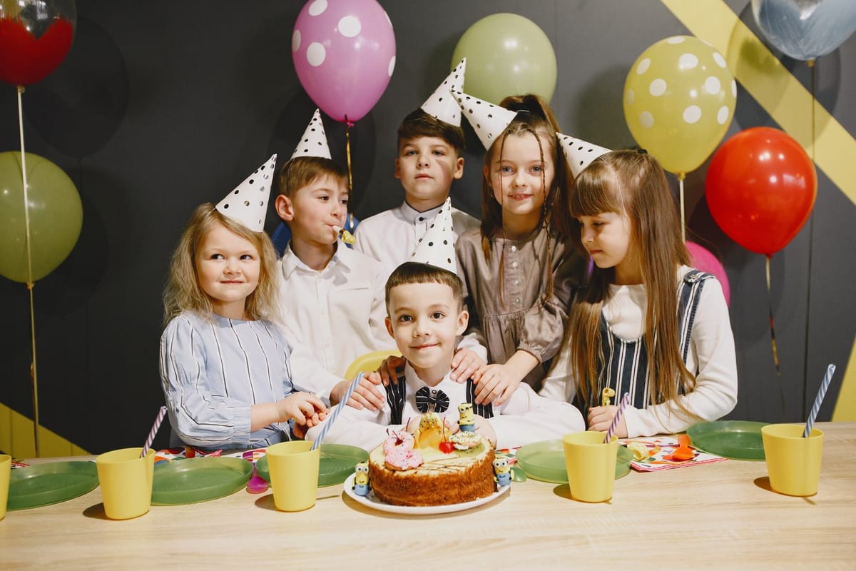 ילדים חוגגים יום הולדת עם עוגה ובלונים
